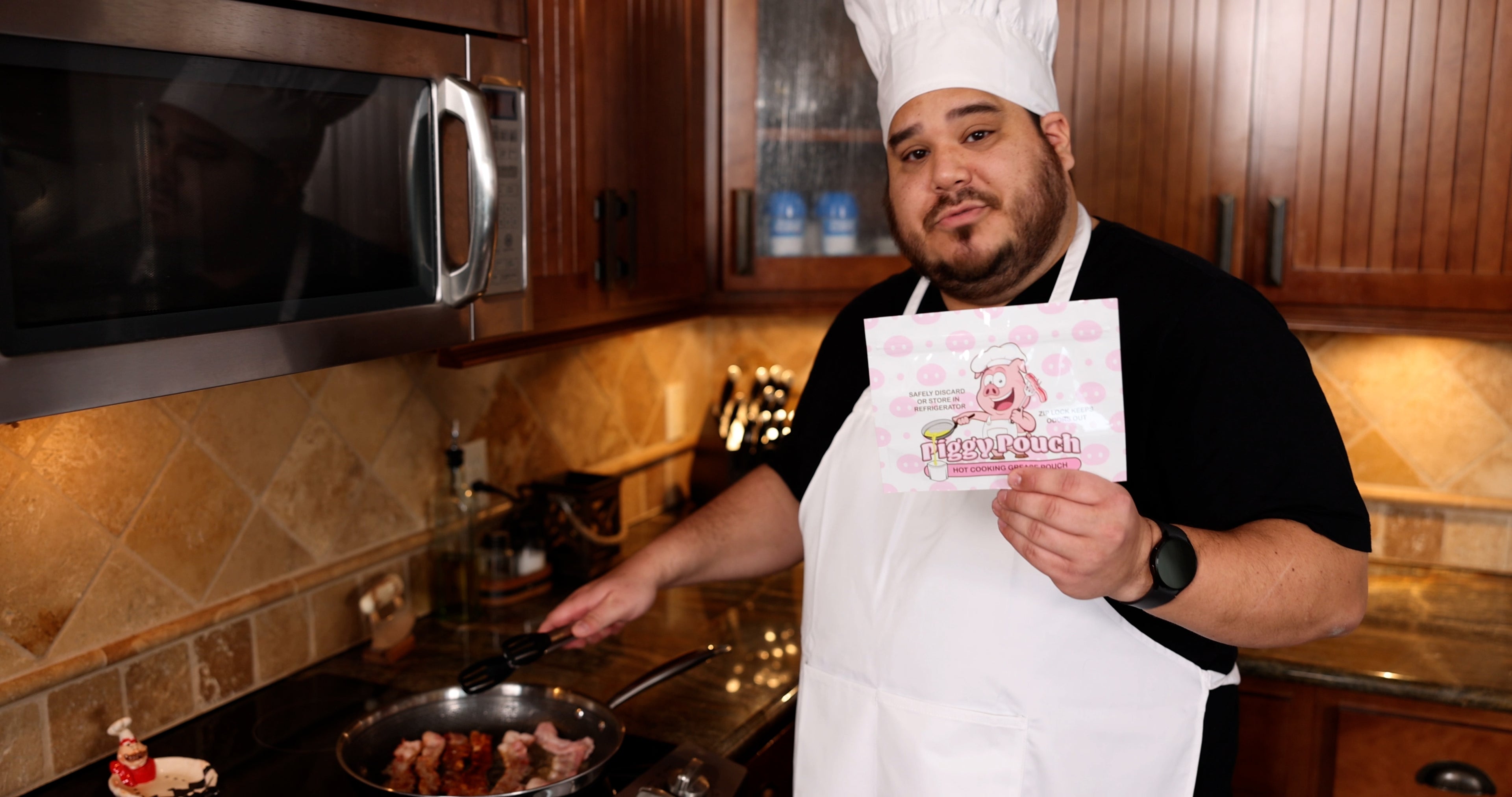 Picture of a man cooking bacon while holding up on display a piggy pouch bacon grease container